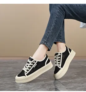 Detailopname van zwarte kanten damessneakers met ademend mesh en dikke witte zolen