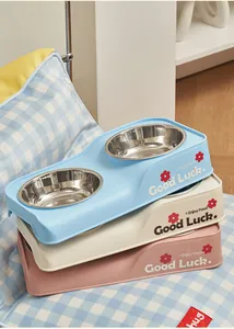 Detail view of stacked double stainless steel pet bowls in pastel blue, cream, and pink