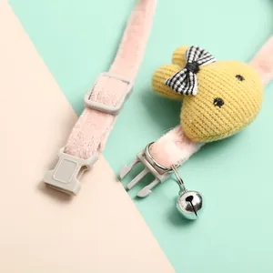 Macro detail of a pink plush pet collar featuring a yellow knitted bunny and bell