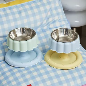 Gamelles surélevées en inox pour animaux, couleurs pastel sur tapis damier.