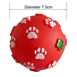Close-up detail of a red squeaky pet toy ball with paw prints, measuring 7.5cm diameter