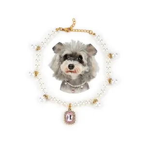 Detail shot of pet pearl necklace featuring a large pink gemstone pendant for dogs