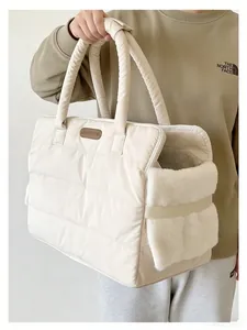 Close-up of a large beige quilted pet carrier bag with plush detail and soft handles