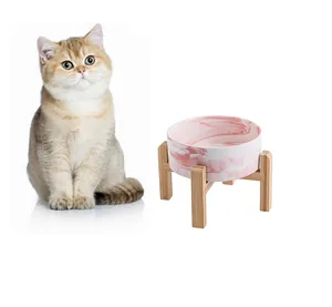 Vue détaillée du bol en céramique marbre rose et support en bambou avec un chat prop