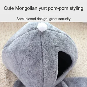 Cama para gatos de felpa gris semicerrada con detalle de pompón blanco en alfombra