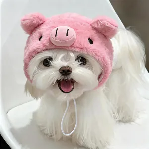 Close-up of a fluffy white dog wearing a cute pink pig-themed plush pet headgear