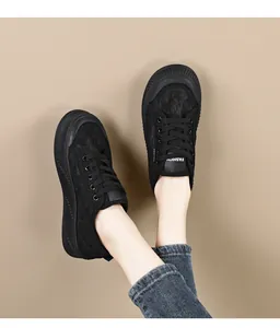Detail van ademende zwarte platform sneakers voor dames gedragen met een jeans
