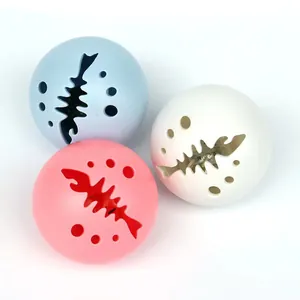 Detalle de tres pelotas brillantes para gatos con recortes de espinas de pescado.