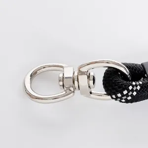 Macro view of the durable metal swivel snap hook on a reflective nylon dog leash