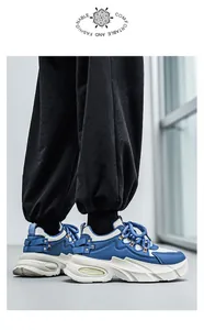 Κοντινό πλάνο μοντέρνων μπλε-λευκών chunky sneakers με χοντρή σόλα και μαύρο παντελόνι