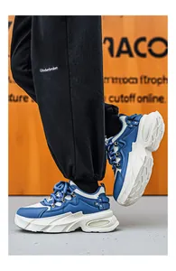 Λεπτομερής πλάγια όψη μπλε και λευκών chunky sneakers με χοντρές σόλες πλατφόρμας