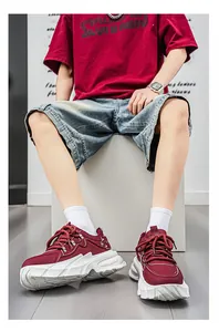 Λεπτομέρεια από μπορντό ανδρικά chunky sneakers με χοντρές λευκές σόλες και ανάγλυφη υφή.