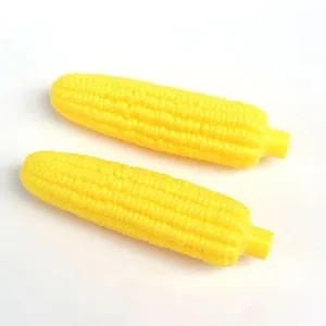 Macro detail of yellow corn-shaped squeaky dog chew toy showing textured kernels