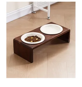 Support de gamelle surélevé en acacia avec deux bols en céramique sur parquet