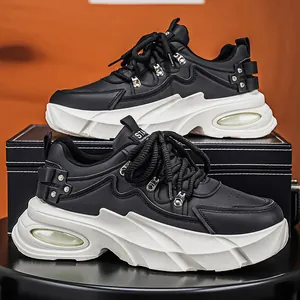 Μοντέρνα μαύρα chunky sneakers για άνδρες με χοντρές λευκές σόλες και μεταλλικά τρουκς.