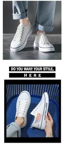 Detail view of stylish white low-top canvas sneakers with trendy side printing.
