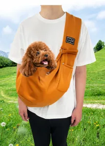 Comfortable orange pet sling carrier for small dogs and cats being worn by a person outdoors