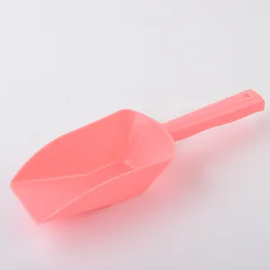 Vista detallada de una resistente pala de plástico rosa para alimentar a mascotas con mango.