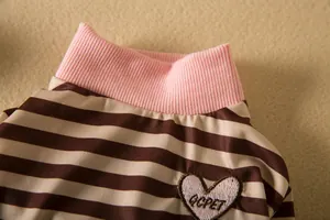 Close-up of pink ribbed collar and striped fabric on a pet shirt with heart patch
