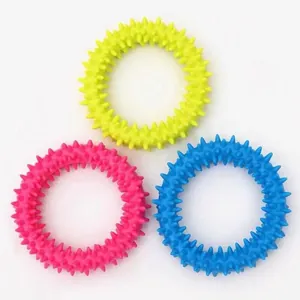 Detailed macro view of three colorful TPR spiked rings for puppy teeth cleaning and oral health