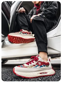 Detail view of breathable ethnic pattern men's sneakers with red laces and thick sole.