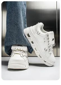Dettaglio di sneakers punk bianche con anelli metallici e suola platform in pelle