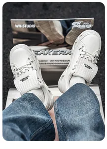 Dettaglio sneaker punk bianche con zeppa, catene metalliche pesanti e borchie