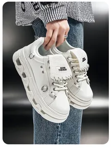 Vista dettagliata di sneaker platform punk bianche con accessori ad anello in metallo.