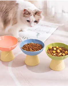 Macro detail of three elevated pastel pet bowls with textured cone bases and cat food