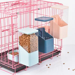 Hanging automatic pet feeder attached to pink wire cage filled with dry dog kibble