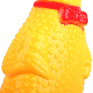 Close-up of a yellow screaming chicken dog toy featuring bumpy texture and red bow tie