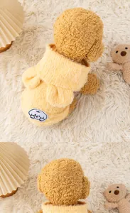 Detail view of a cozy yellow plush pet hoodie featuring a cute cartoon patch on the back.