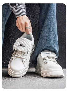 Dettaglio ravvicinato di sneaker bianche punk con zeppa e decorazioni ad anello