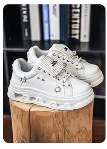 Vista dettagliata di sneaker bianche punk con plateau e anelli metallici