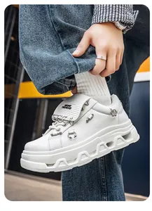Dettaglio di sneaker punk bianche con anelli metallici e suola platform spessa uomo