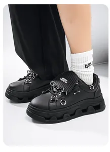 Primo piano di sneakers punk nere con suole platform e dettagli con anelli in metallo