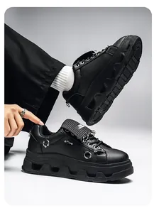 Dettaglio di sneaker punk nere con plateau, inserti in anelli metallici e suola spessa