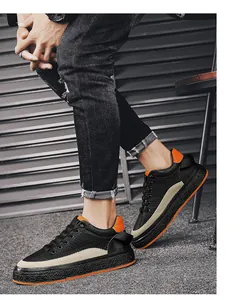 Zijaanzicht van dikke herensneakers met oranje accenten en zwart getextureerd.