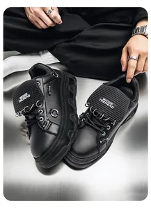 Dettaglio di sneakers punk platform nere con catene e anelli in metallo argento.