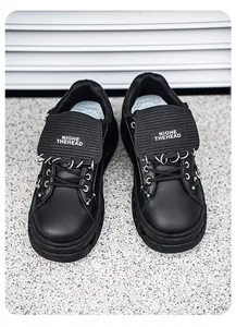 Vista dettagliata delle sneakers nere punk platform con anelli in metallo pesante