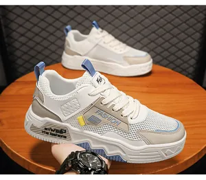 Primo piano di sneaker in mesh bianco e grigio con dettagli blu su un tavolo in legno.