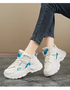 Détail de baskets compensées blanches avec touches bleues et doublure fourrure.
