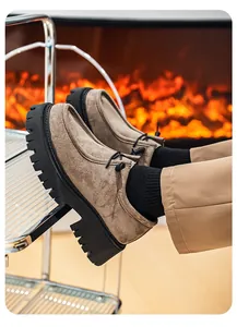 Detalle de zapatos de gamuza con suela de plataforma en un ambiente acogedor junto al fuego.