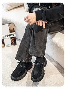 Detalle de zapatos de ante negro de alta calidad combinados con vaqueros grises.
