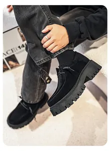 Primer plano detallado de zapatos slip-on de ante negro para hombre con suela de plataforma.