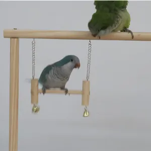 Natural wooden parrot training stand gym featuring a swing with bells and two birds