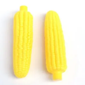 Close-up macro view of two bright yellow squeaky corn dog toys for pet teething and play
