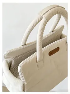 Close-up of beige quilted pet carrier bag showing breathable mesh and soft plush trim