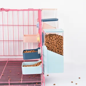 Hanging pet automatic gravity feeder and bowls attached to a pink wire cage for dogs