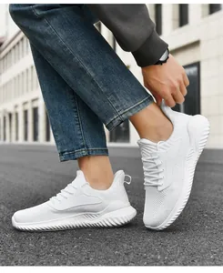 Nahaufnahme von weißen, atmungsaktiven Fly-Knit Dad-Schuhen mit dicken Sohlen im Freien.